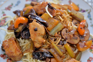 Plate containing Chicken & Wood Ear Mushrooms in Garlic Sauce on a bed of Chinese noodles
