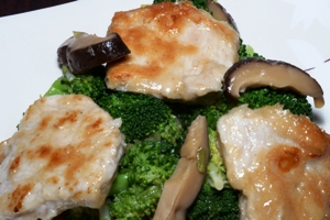 A dish containing Chinese pork, broccoli and black mushrooms