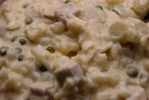 a bowl of glop showing the cauliflower, sweet peas, mornay sauce and turkey