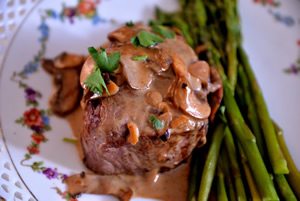 Steak Diane on a white plate with small flowers
